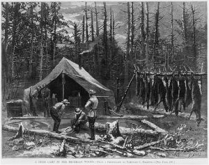 Vintage image of men and deer carcasses at a campsite