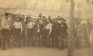 Antique photo of men standing outside holding mugs of beer at the Saginaw Sunflower Club