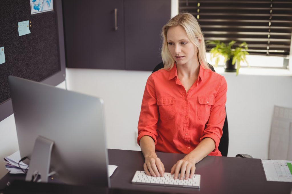 Woman sits at desk on a computer